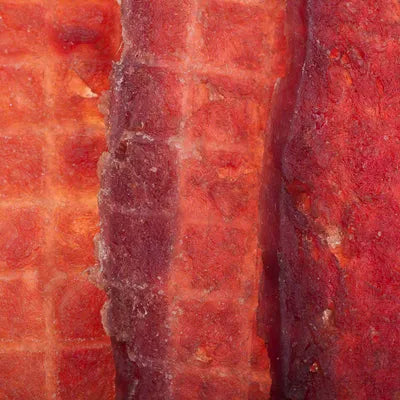 Gros plan sur des lamelles de bœuf séché MonPachaTech, friandises naturelles pour chien à la texture fibreuse.