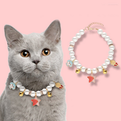 Collier pour chat MonPachaTech orné de perles blanches, breloques étoile et clochettes dorées sur un chat gris